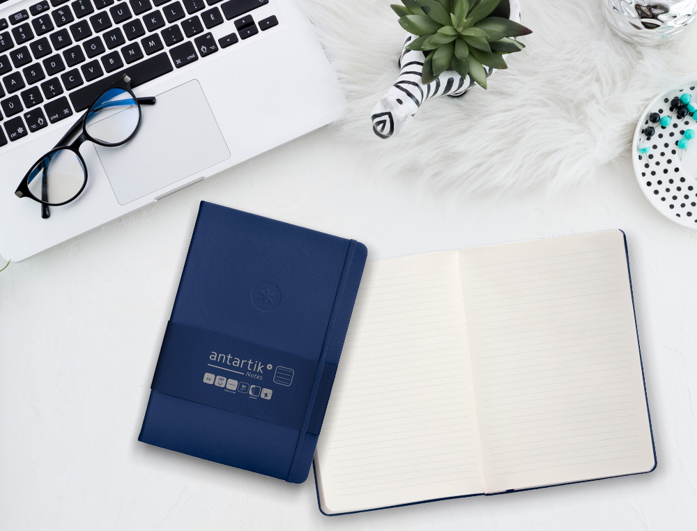 CUADERNO CON GOMILLA ANTARTIK NOTES TAPA DURA A5 HOJAS RAYAS AZUL MARINO 100 HOJAS 80 GR FSC