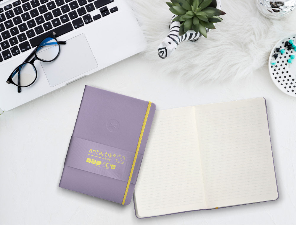 CUADERNO CON GOMILLA ANTARTIK NOTES TAPA DURA A5 HOJAS RAYAS MORADO Y AMARILLO 100 HOJAS 80 GR FSC
